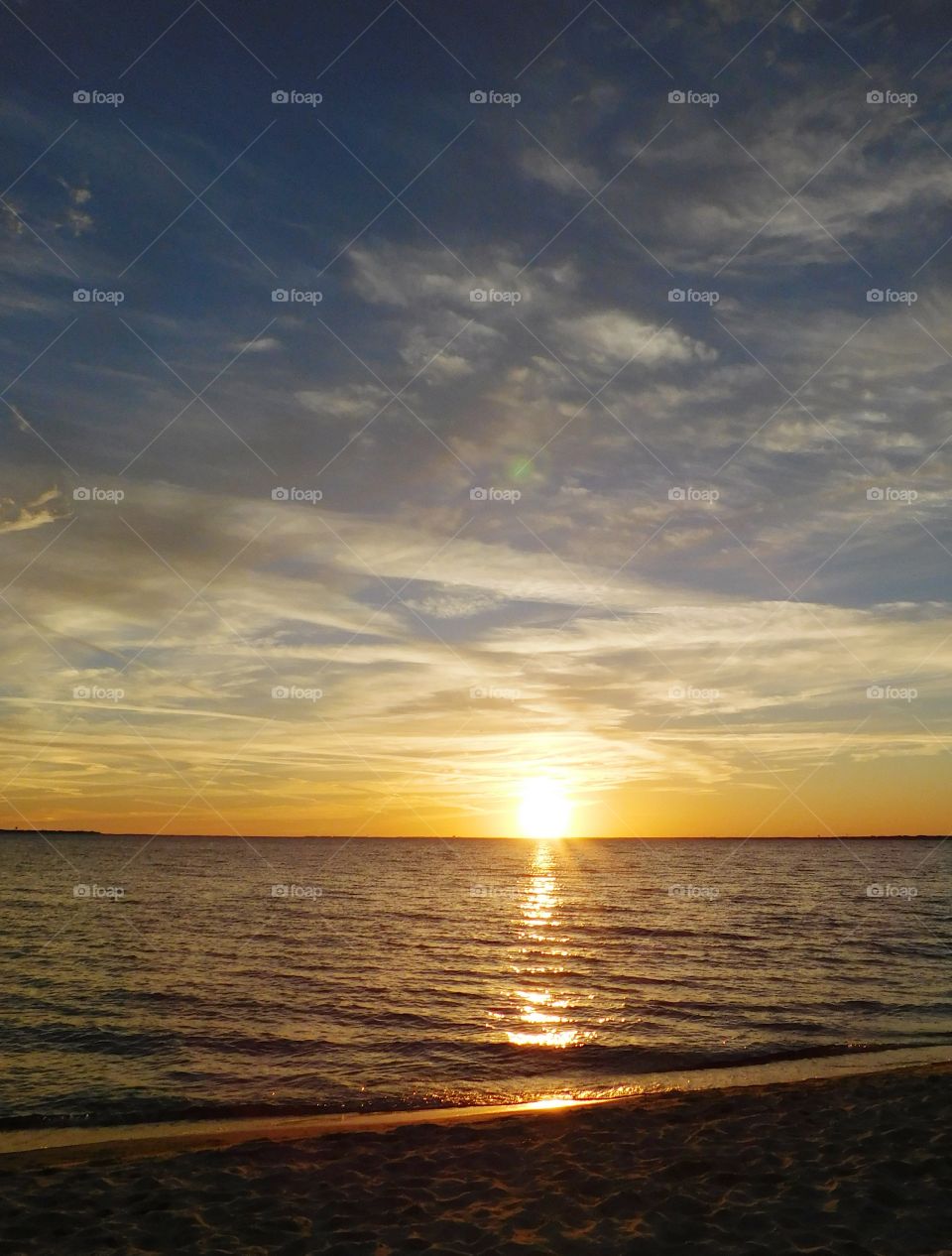 Star like sunset- the sun rays reflect on the surface of bay with the backdrop of multicolored puffy clouds