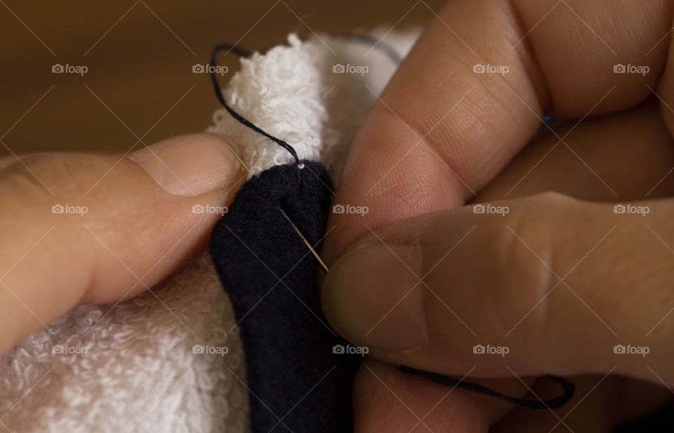 woman hands sewing with needle and thread