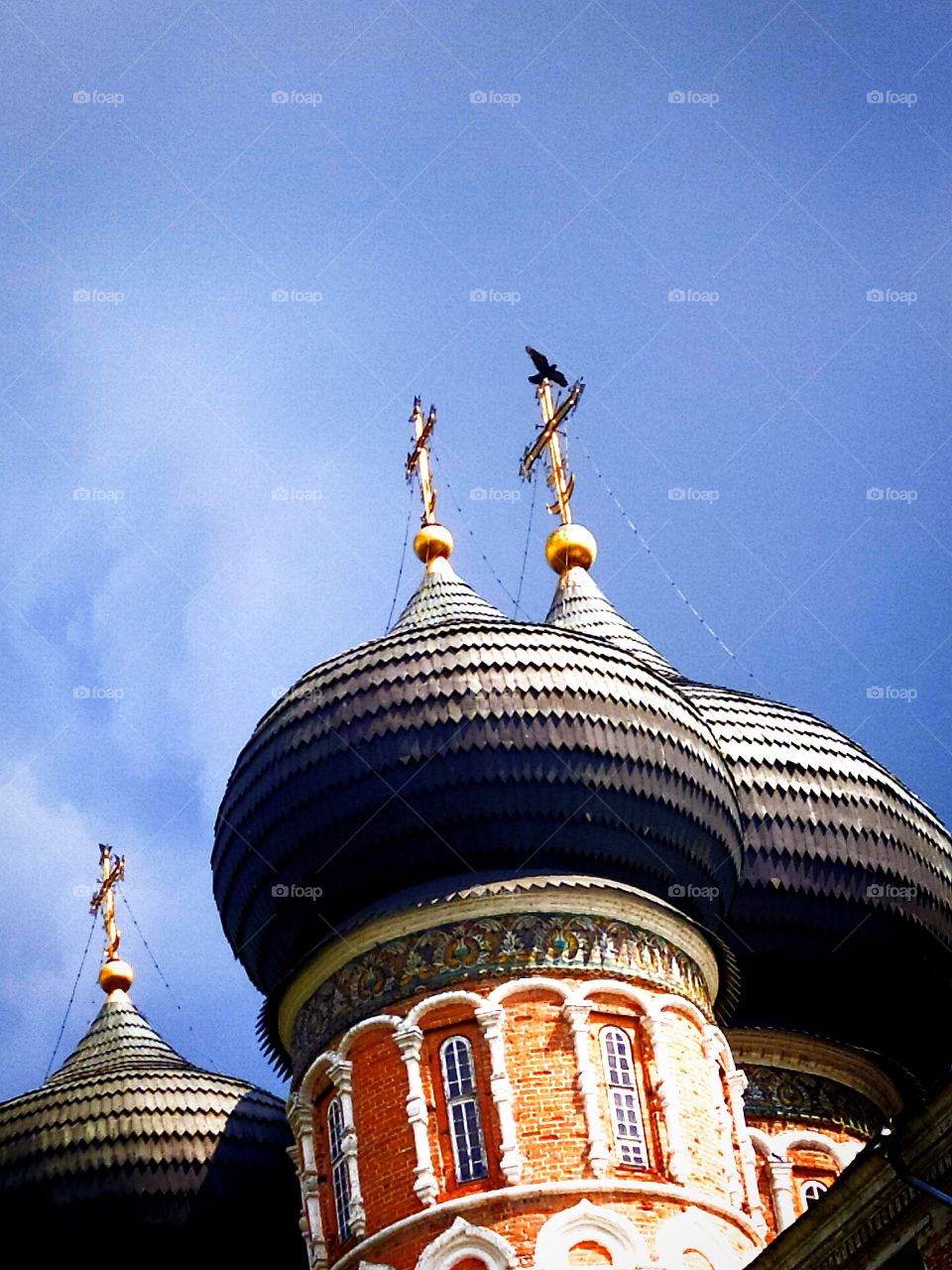 Domes of the temple and a flying dove against the blue sky