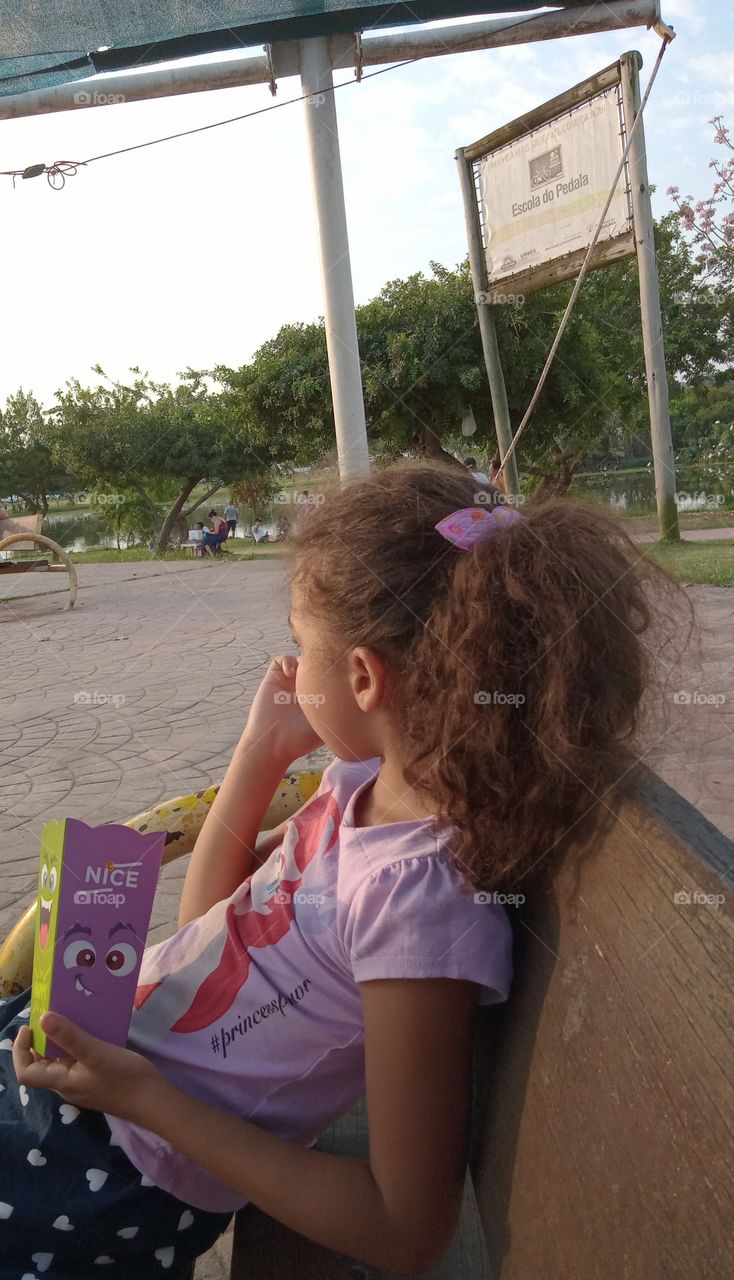 Criança sentada comendo pipoca