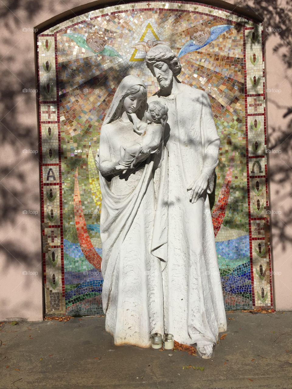 Picture of Mother Mary carrying baby Jesus alongside father Joseph as statutes. This art reflects upon Christianity Jane religion. The family is under the holy trinity .the sculpture are monuments to the Lords good news .