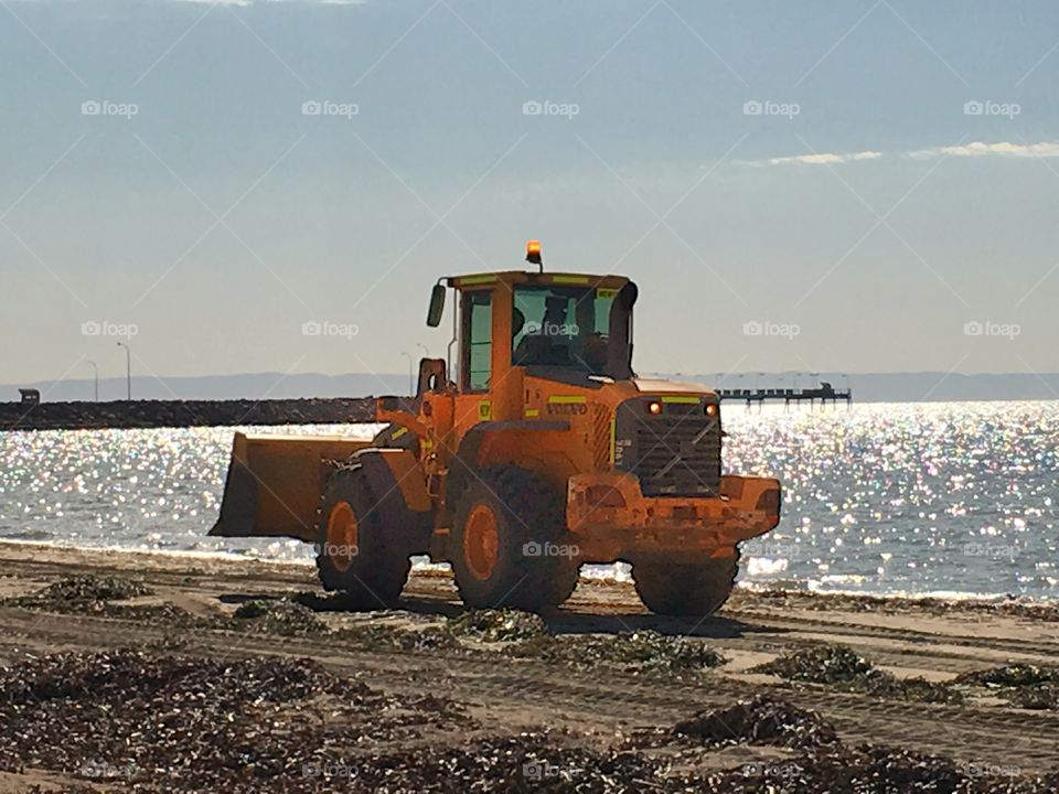 Volvo digger bulldozer dredging the beach in south Australia 