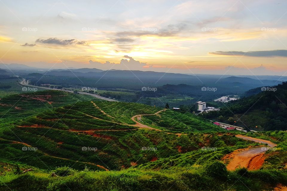 Scenic view of farmland against sunset sky
