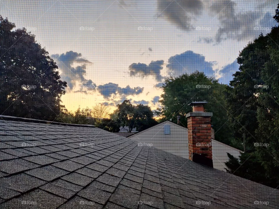 Sunrise and clouds through a screened upstairs window