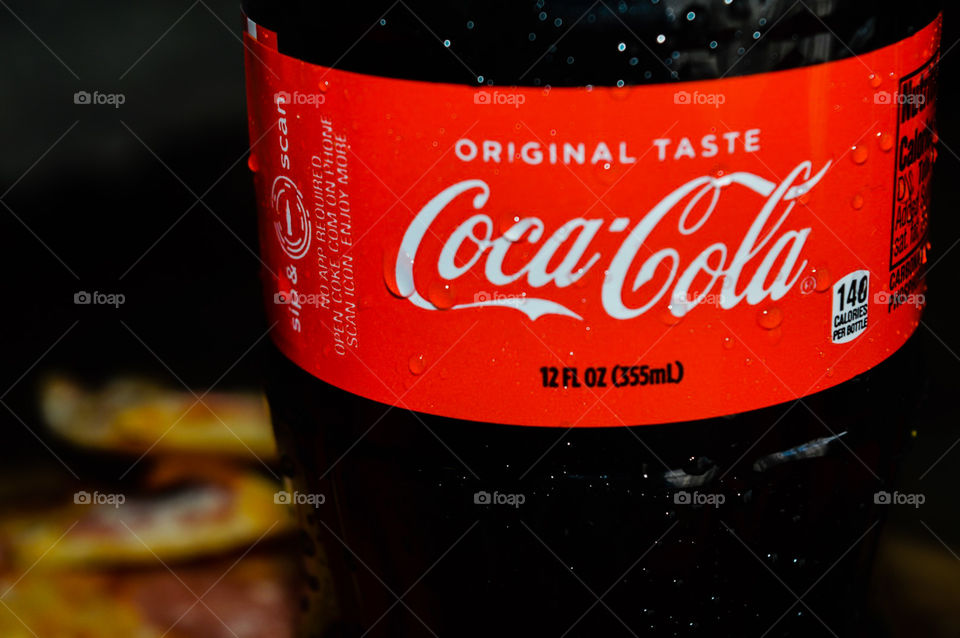 A plastic bottle of Coca-Cola with condensation