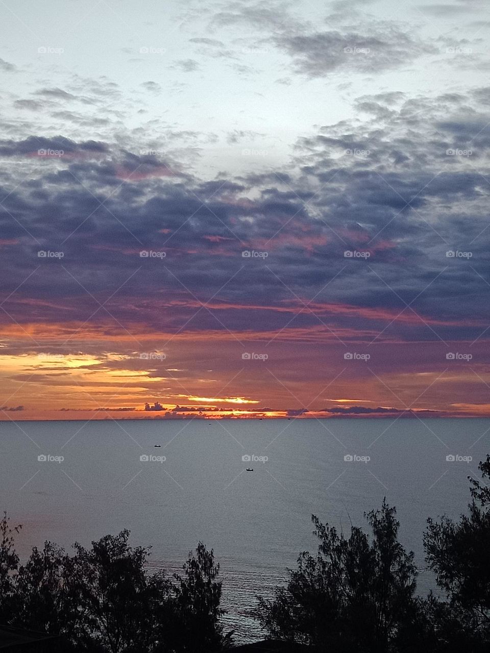 Morning sea with fishing boat passing by