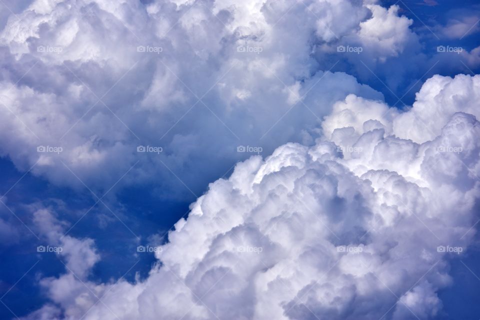 aerial view on fluffy clouds on the blue sky from plane window