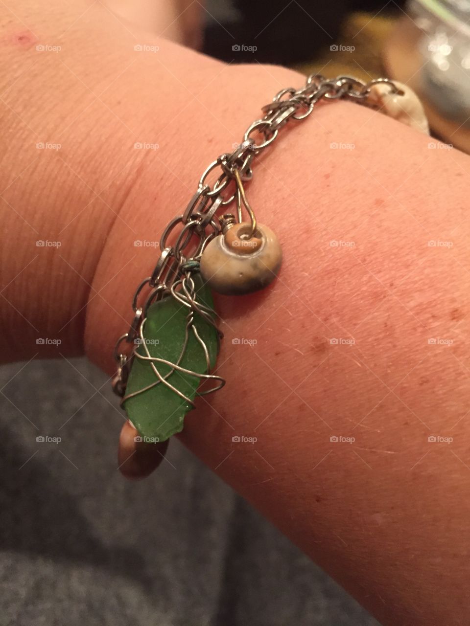 A charm bracelet of favorite shells and wrapped sea glass. 
