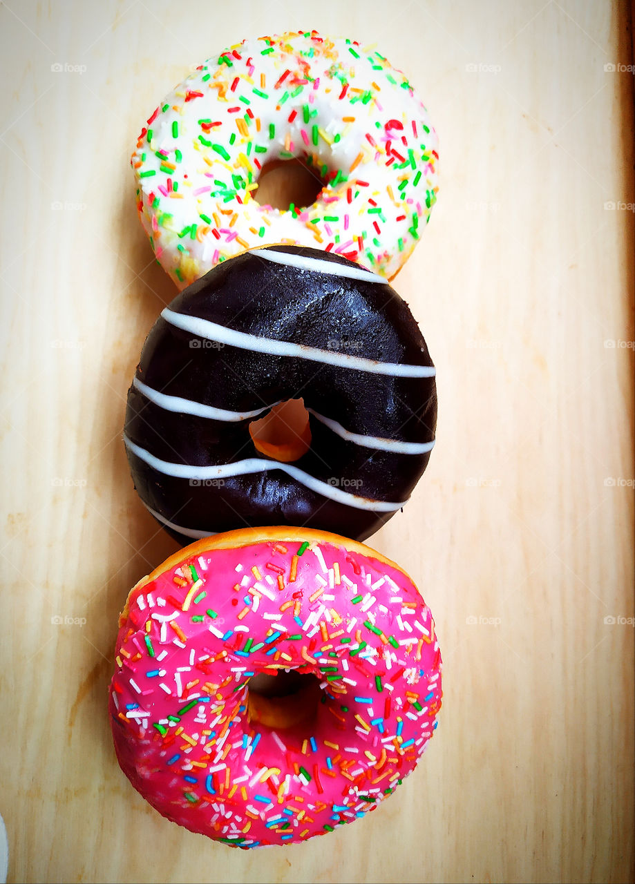 Three multi-colored donuts