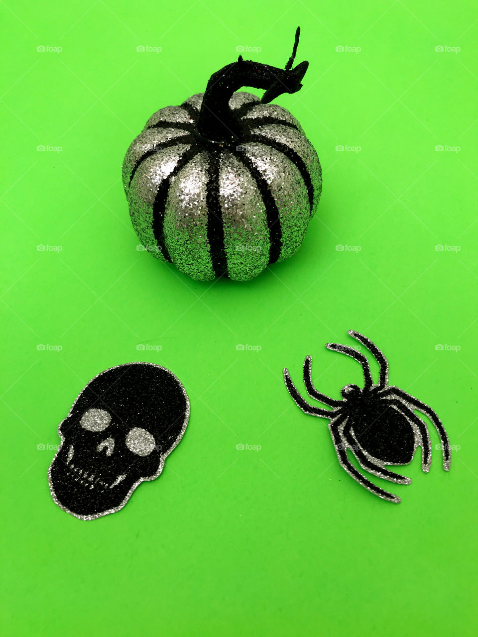 Looking down on a table covered with green paper and silver and black Halloween decorations!