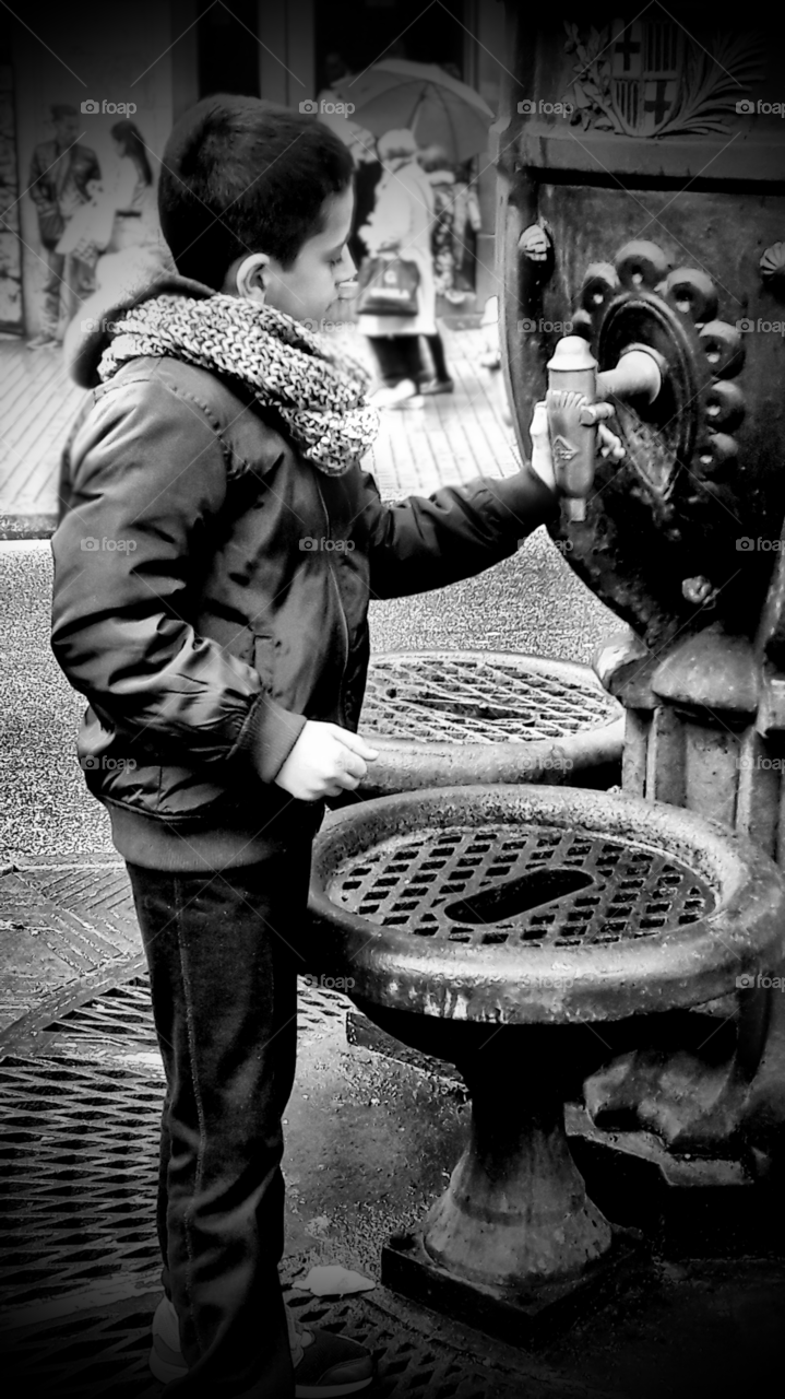 Little boy press faucet drinking water