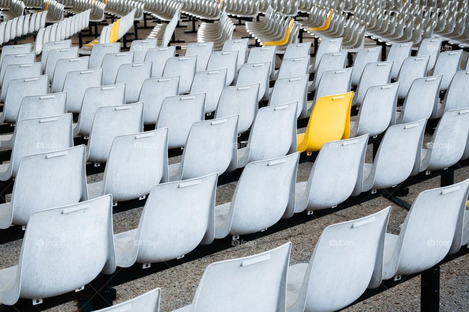 a yellow chair in white chairs