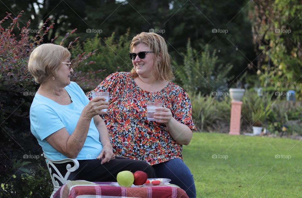 Grandmother and granddaughter having picnic in park