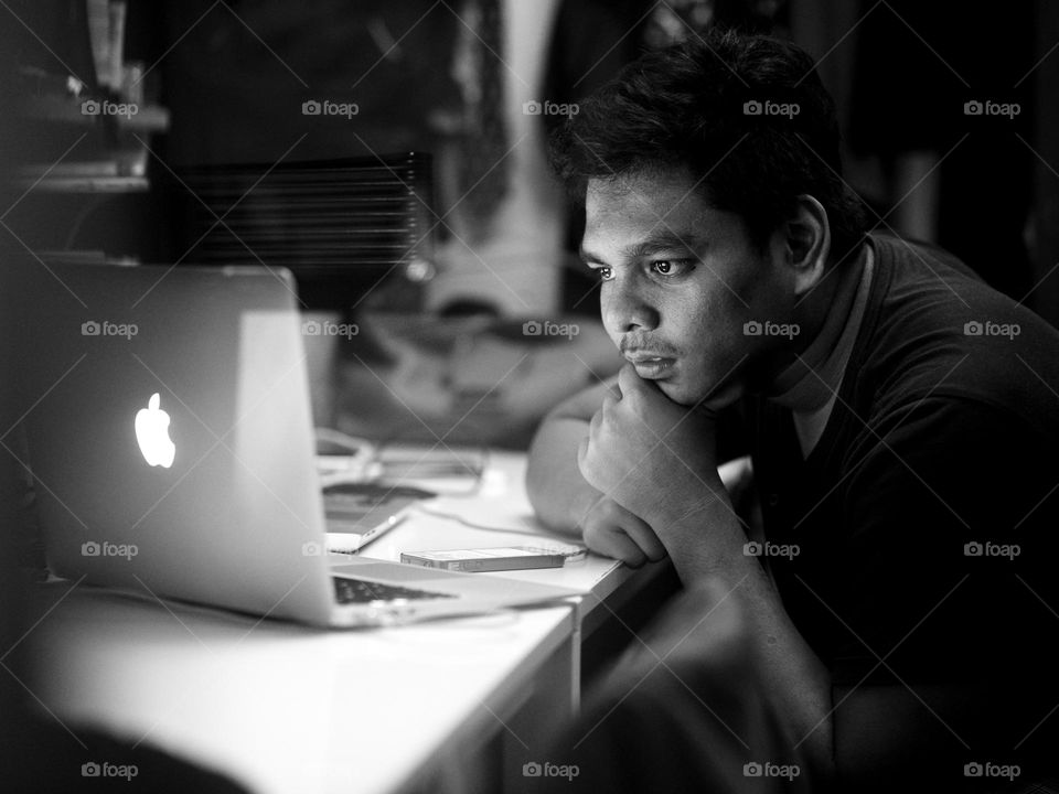 A man deeply in focus on his macbook air