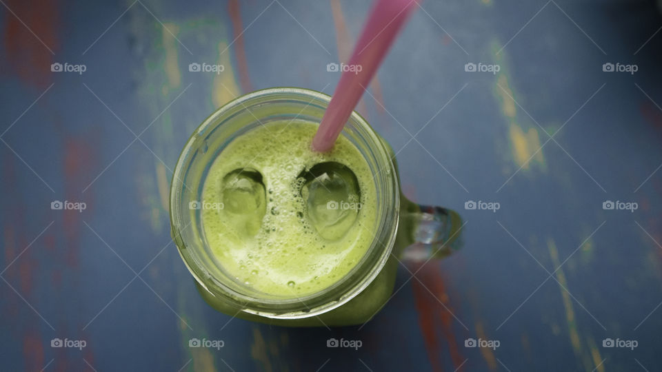 Green juice with straw in glass