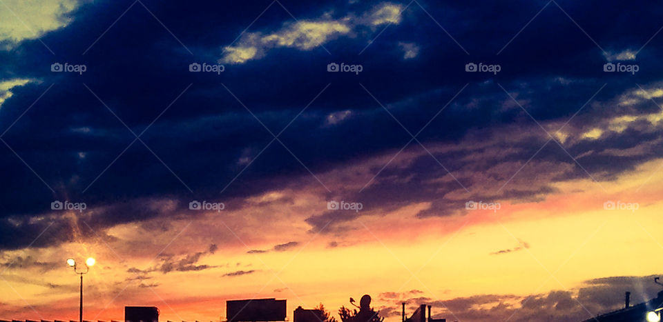 Fiery Sky. A cloudy sunset after a rainstorm. This photo had some work done on it using the phone app Photoshop Express.