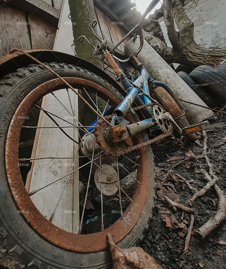 An old children's bicycle among the ruins causes sadness