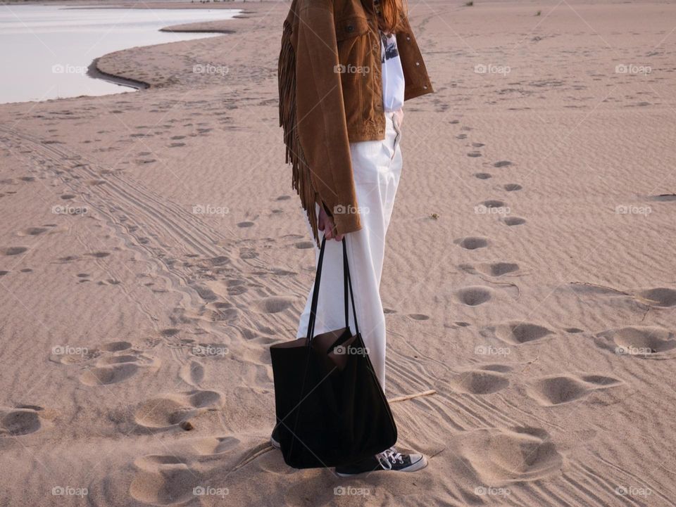 Fashionable dressed girl on the beach during summer