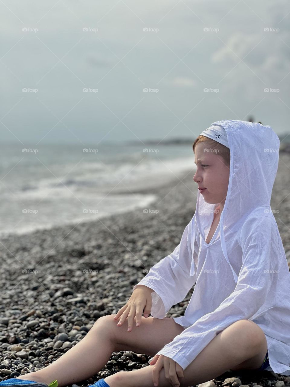 Boy resting meditation on the sea bank