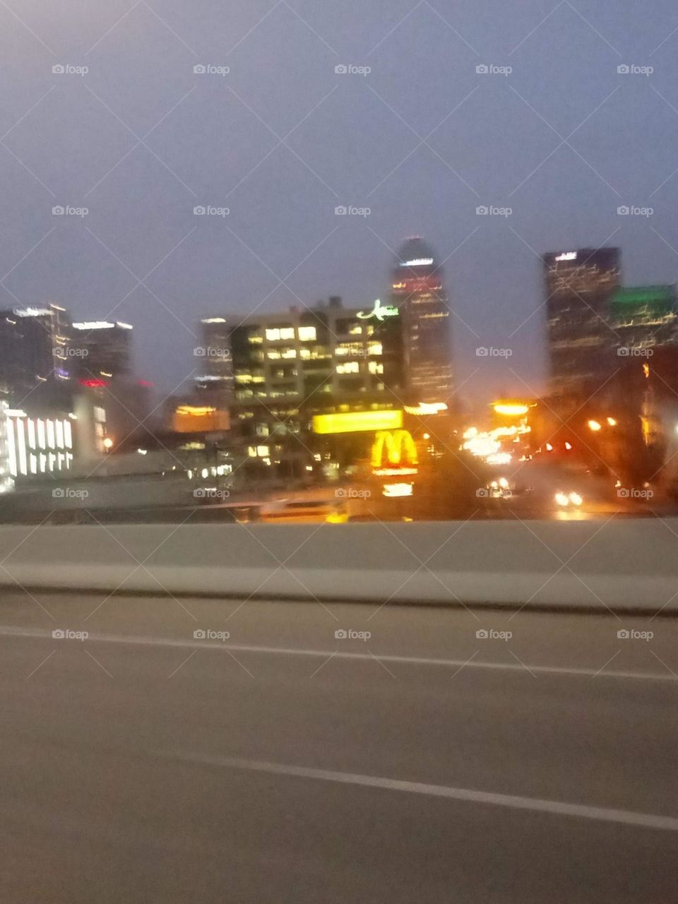 A view of a big city from the highway and the famous McDonalds arches stands out of course 