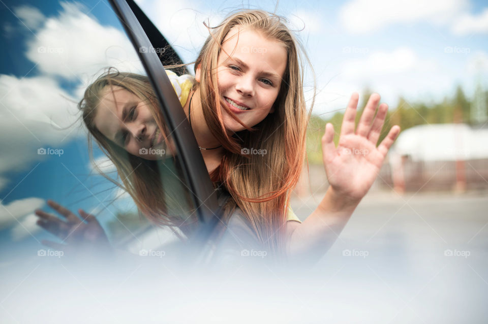 Happy little girl in car window