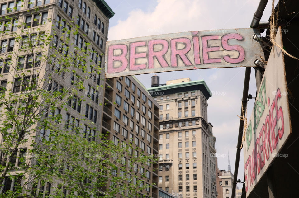 A sign at a street market with high buildings in the background, New York, USA 