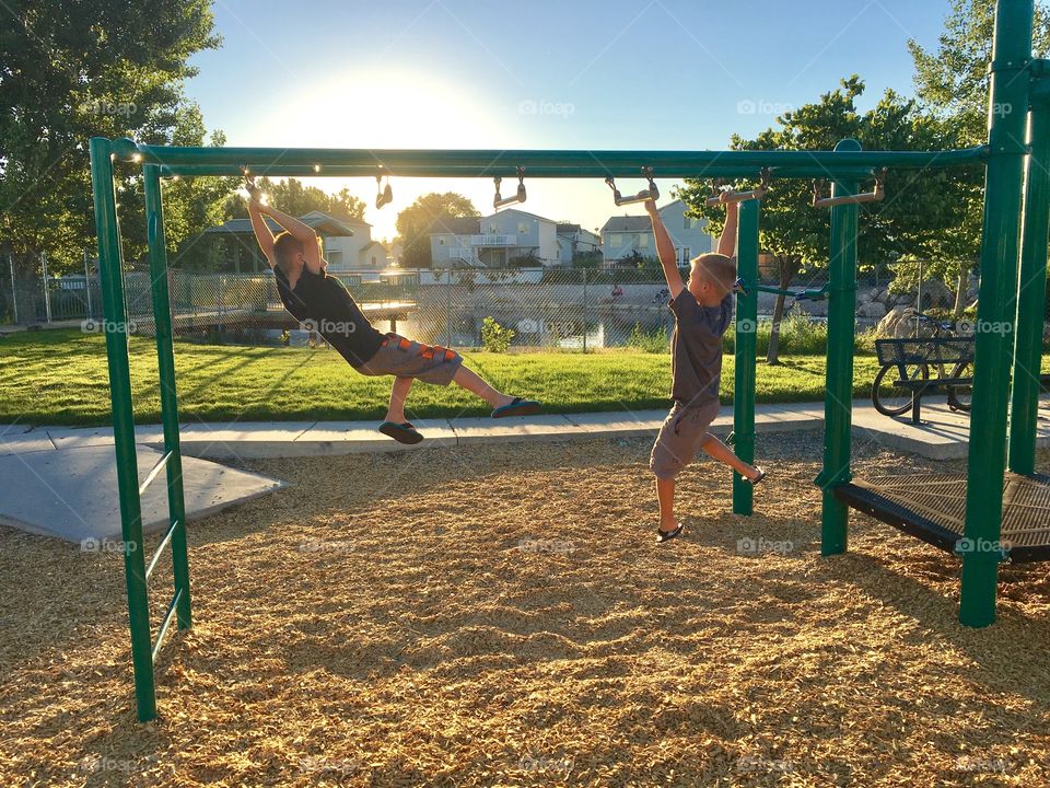 Park. Playground. Play. Two brothers. Two buddies. Two boys. Children. Kids. Fun. Sunset. Beautiful.