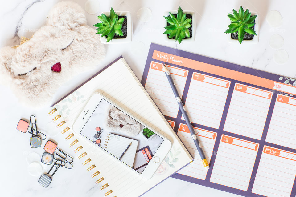 Flat lay desk with mobile phone and weekly planner 