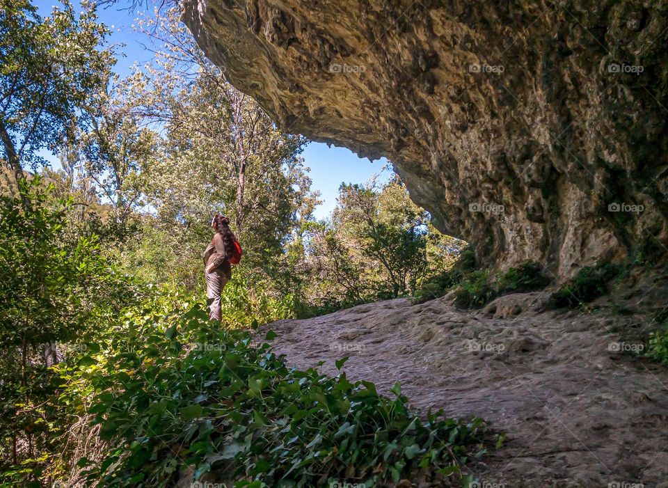 A hiker on a rocky trail admiring the natural surroundings 