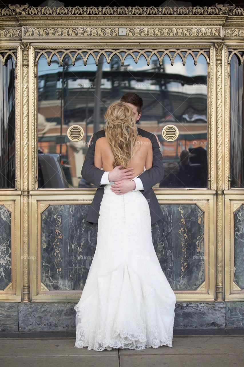 The bride and groom embrace outside of the theatre.