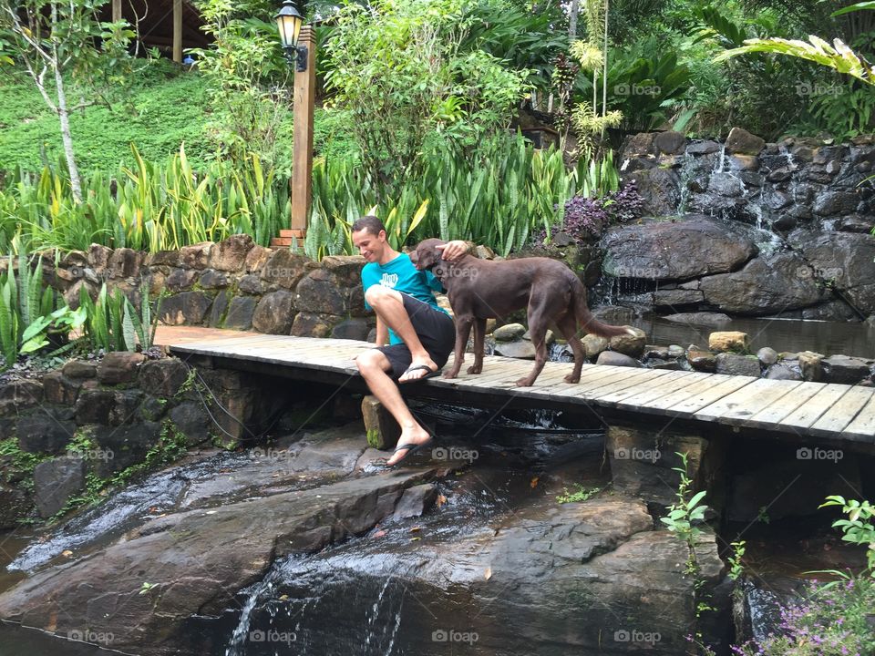 Man with dog on wooden bridge