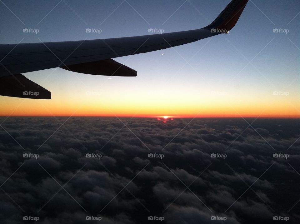 Sunset on a plane . View on the sunset above the clouds 