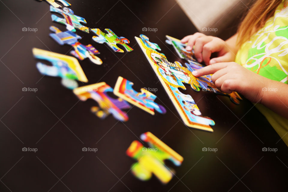 Girl playing jigsaw puzzle on table