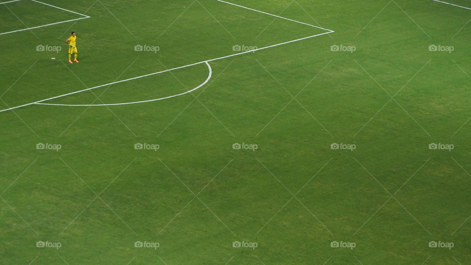 Goalkeeper, isolated. Isolated lonely soccer goalkeeper soccer player contemplating teammates