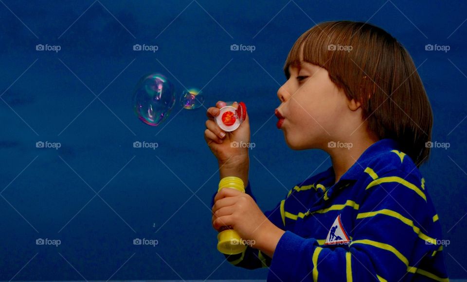 Little Kid Playing With Soap Bubbles. Little Kid Playing With Soap Bubbles