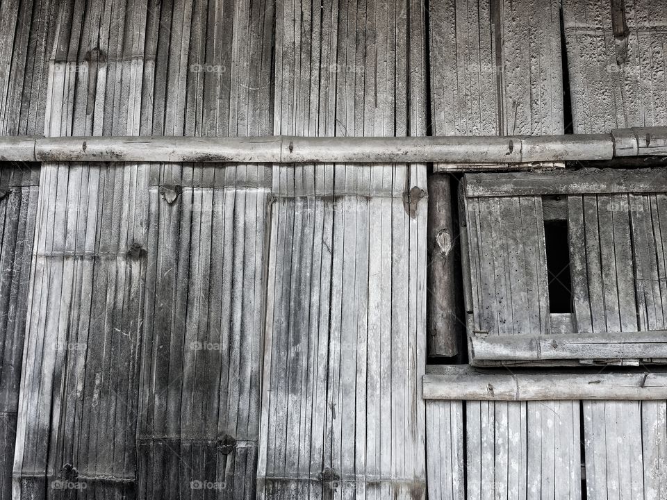 The walls of the house are made from bamboo in a rural area in Thailand. The rural people built simple houses, looking for natural materials to build houses.