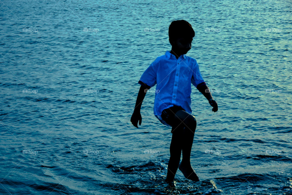 boy at beach playing with sea water.
innocent, evening time