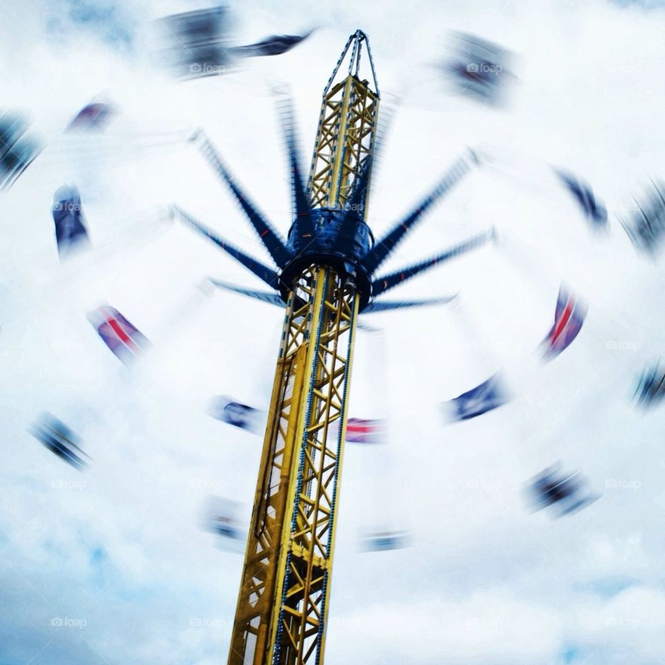 Slow motion shot of fairground ride with blurred national flags.