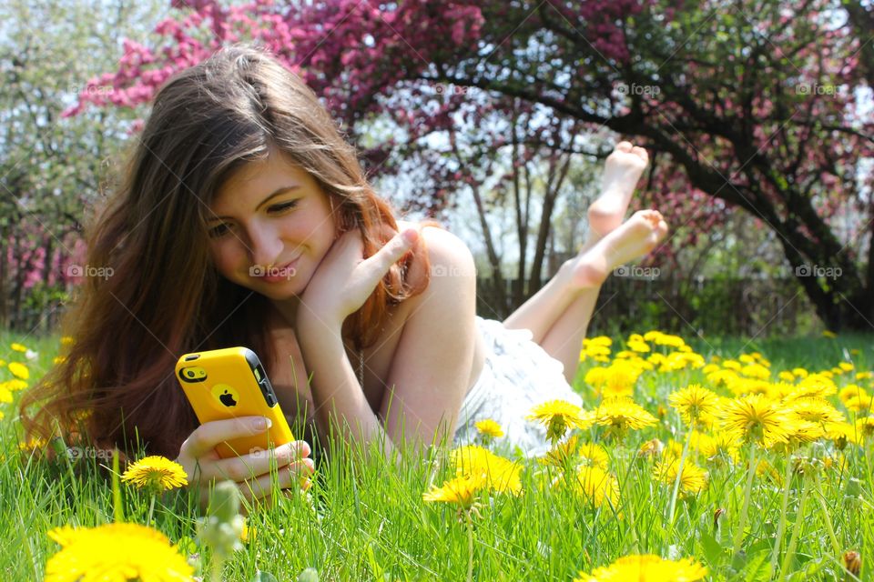 Woman lying on grass with mobile phone
