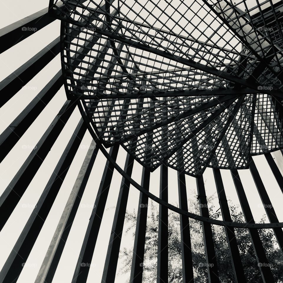 
Low angle view: Spiral staircase seen from below set against the sky.