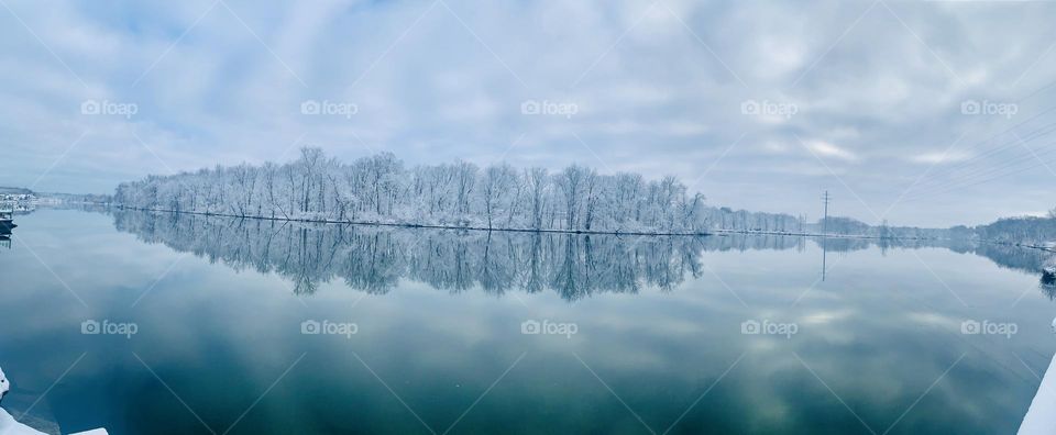 Snowy ice reflection off still river. 