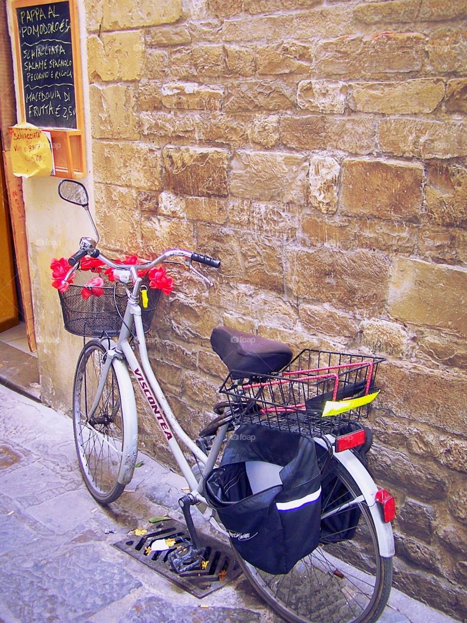 A bicycle parked next to the entrance of the home of Dante Alighieri, the Italian poet famous for his work the Inferno