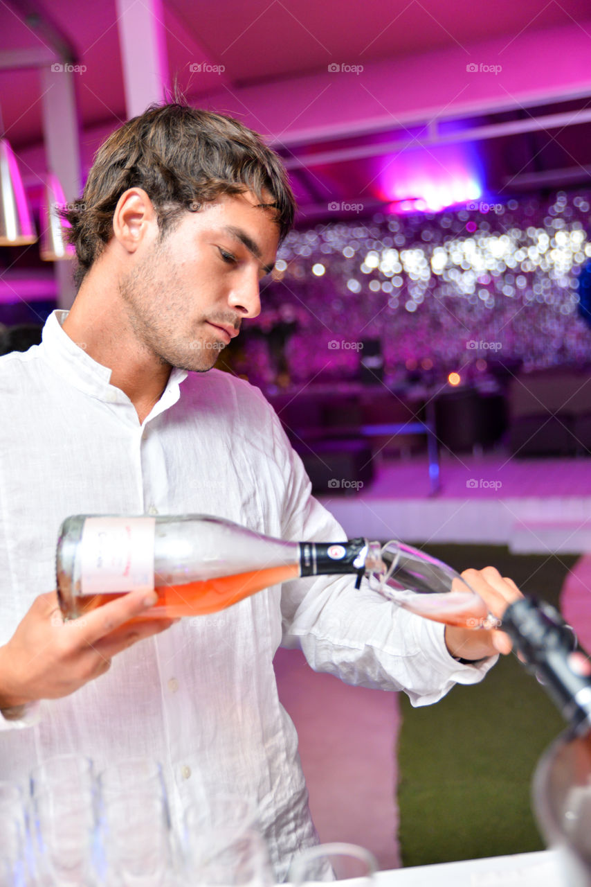 Bartender puring wine in a glass