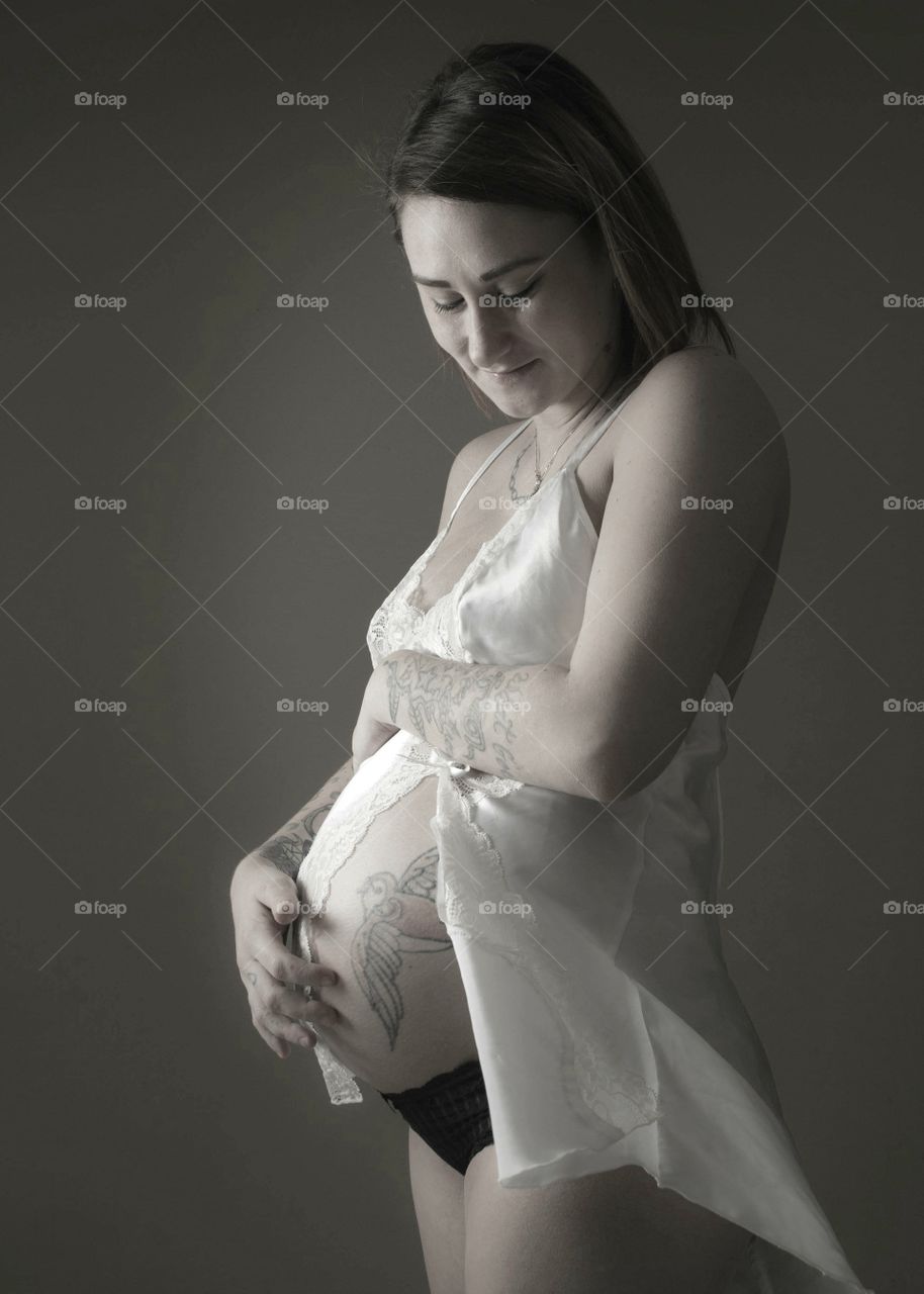 black and white image of beautiful moment showing the love a pregnant woman has for her soon to be born child