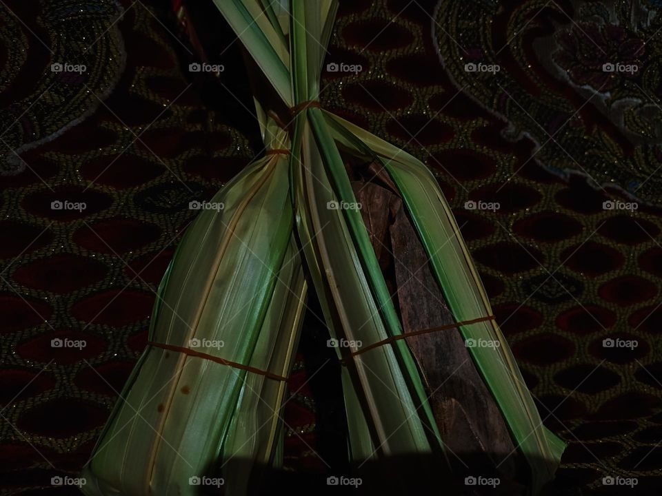 This is palm sugar which is traditionally
made and wrapped in nipa leaves against a red cloth background before being used as a cooking ingredient