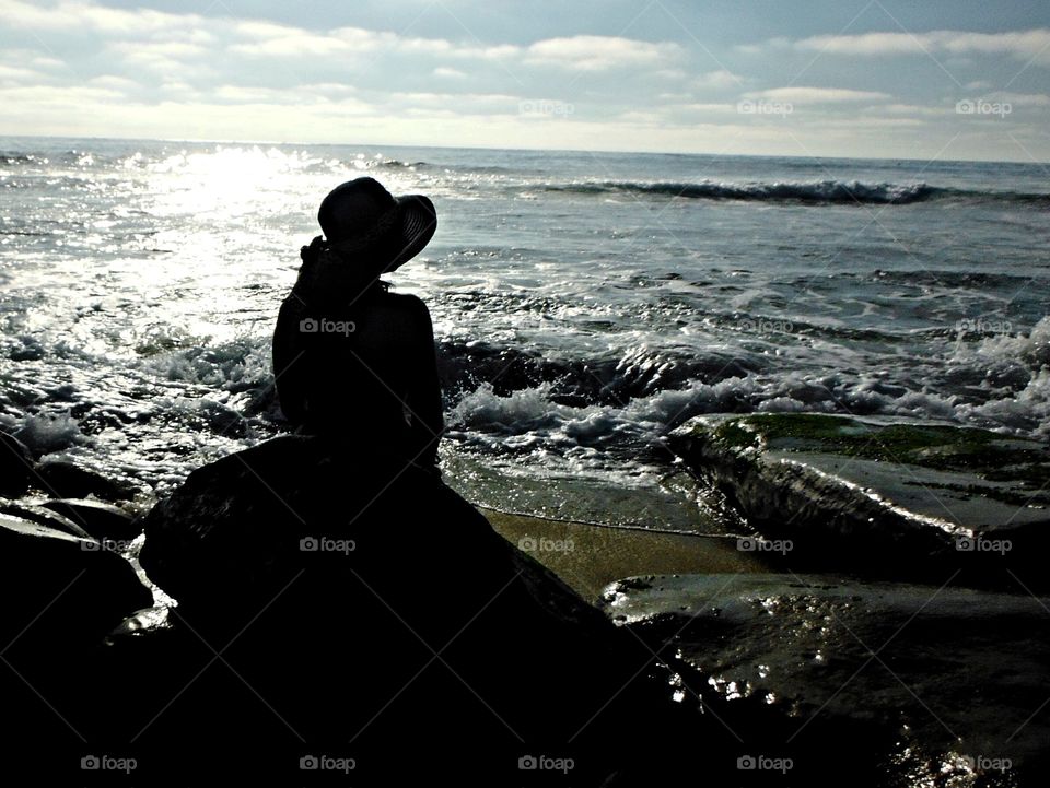 Girl contemplating the ocean waves