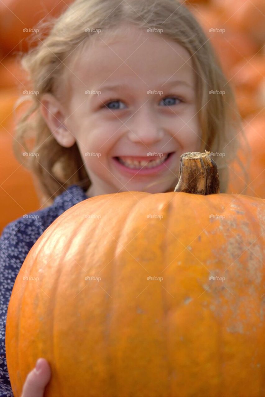 Happy girl holding pumpkin