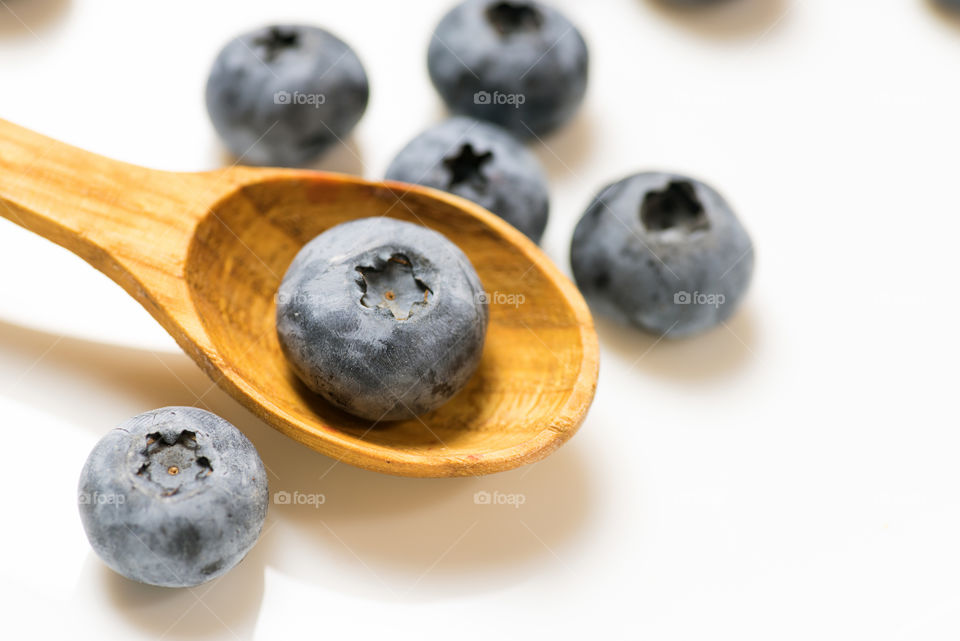 Ripe blueberries close up on white background