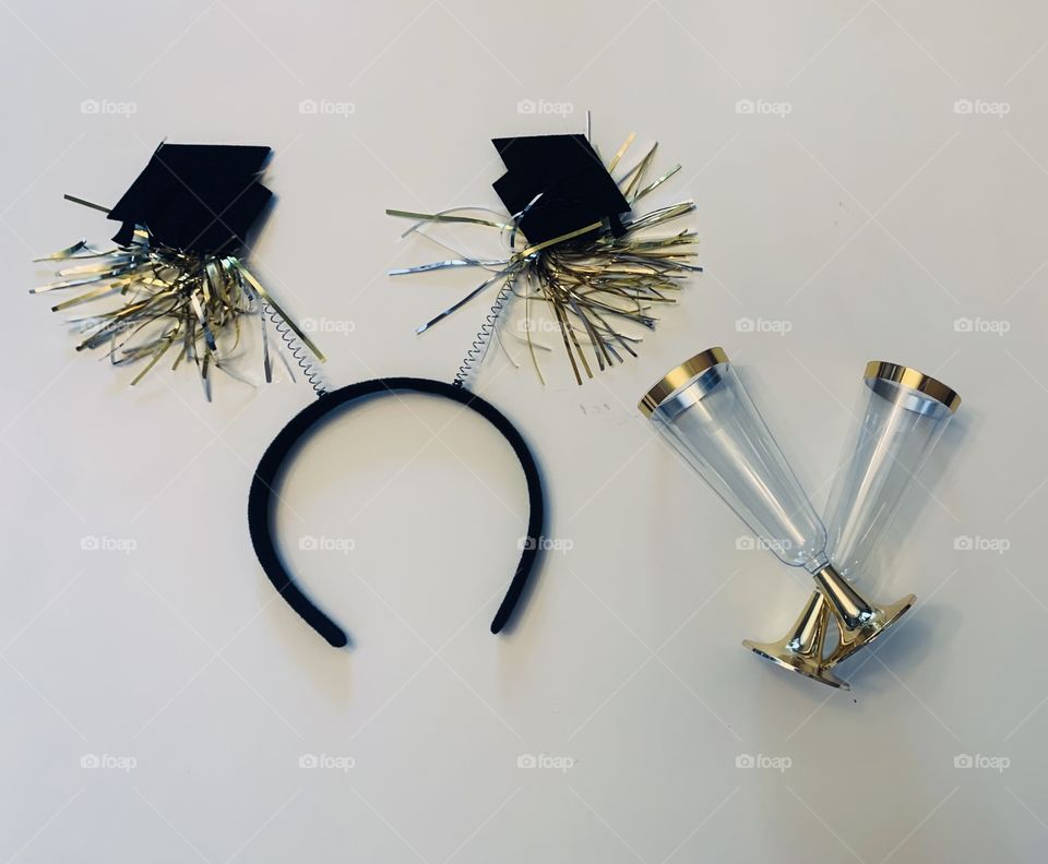 Graduation flat lay- graduation cap with gold and silver tassels and 2 glasses - cheers 