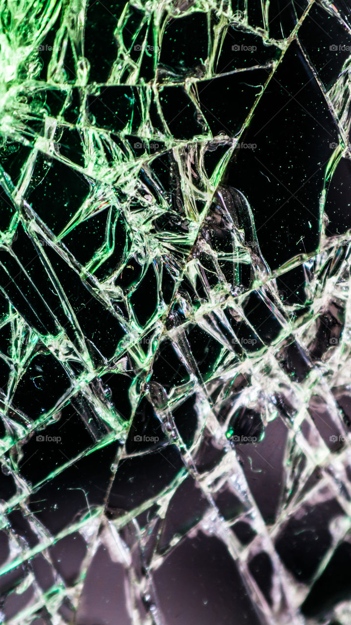 Multi-colored and bright broken smartphone screen close-up.